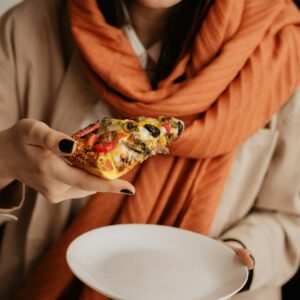 Iranian woman eating a slice of pizza