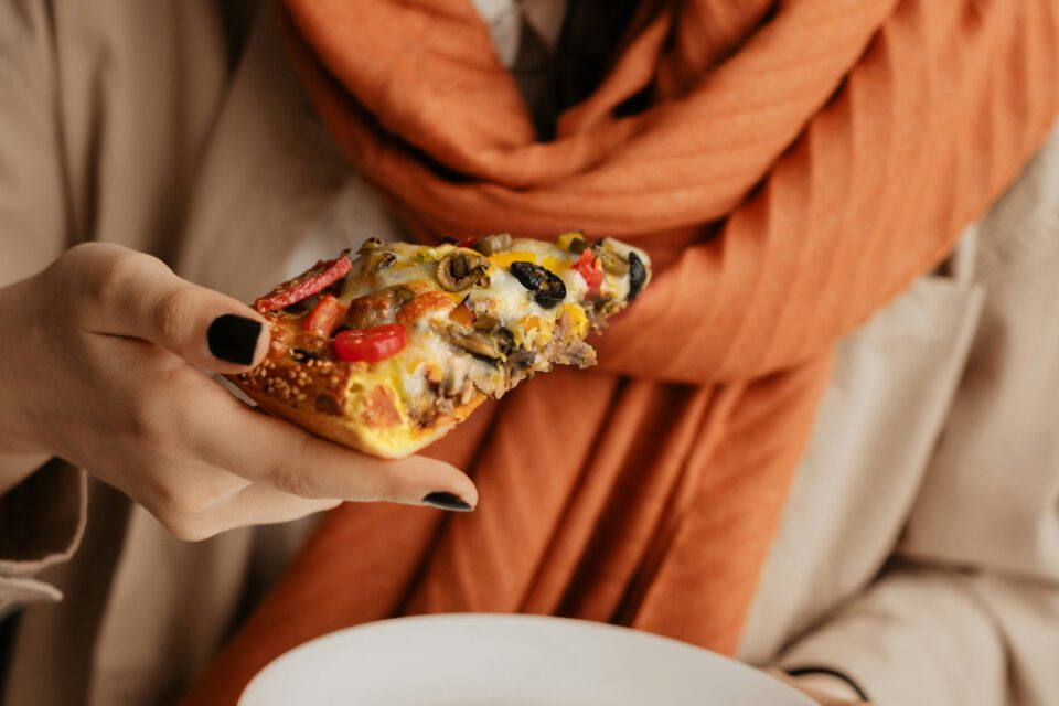 Iranian woman eating a slice of pizza